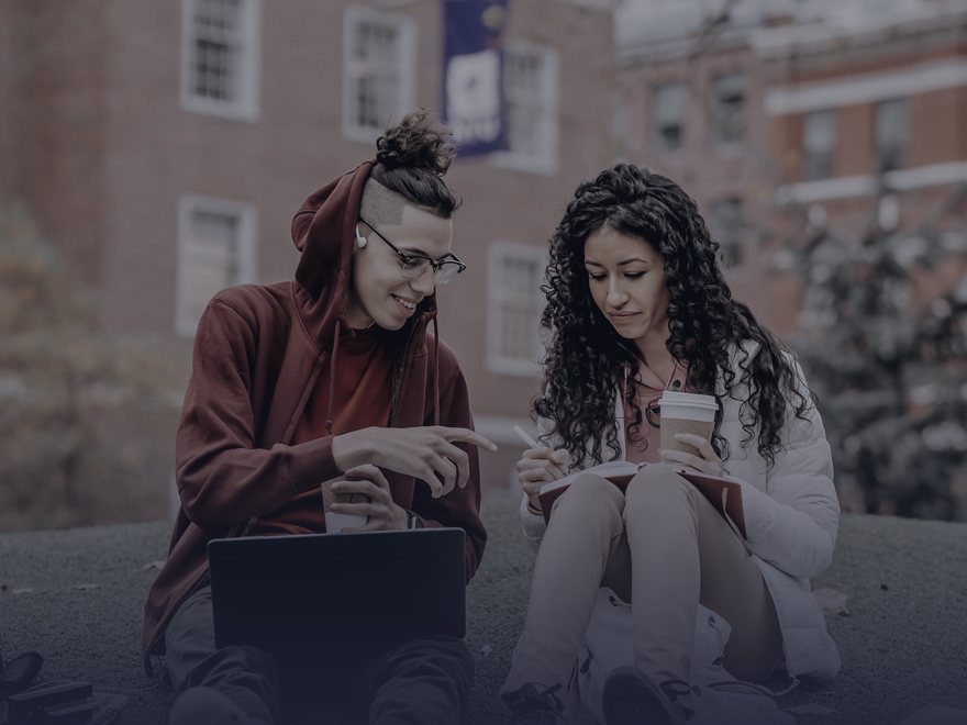 Dois estudantes estudando juntos com laptop e caderno