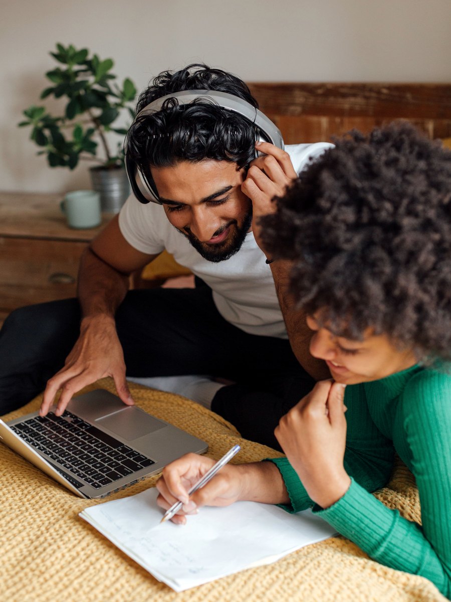 Dois alunos estudando inglês juntos, com notebook e caderno de anotações