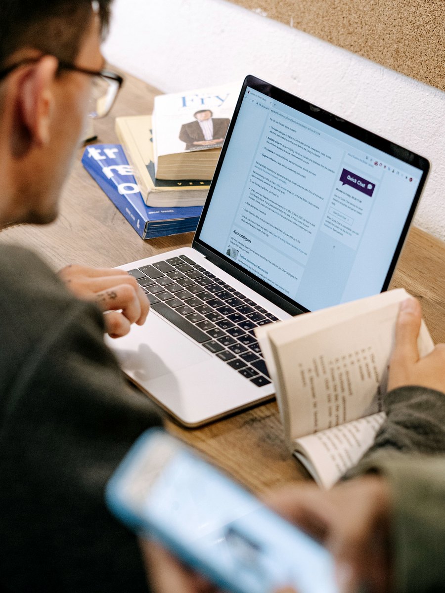 Aluno estudando para o TOEFL com livro e notebook