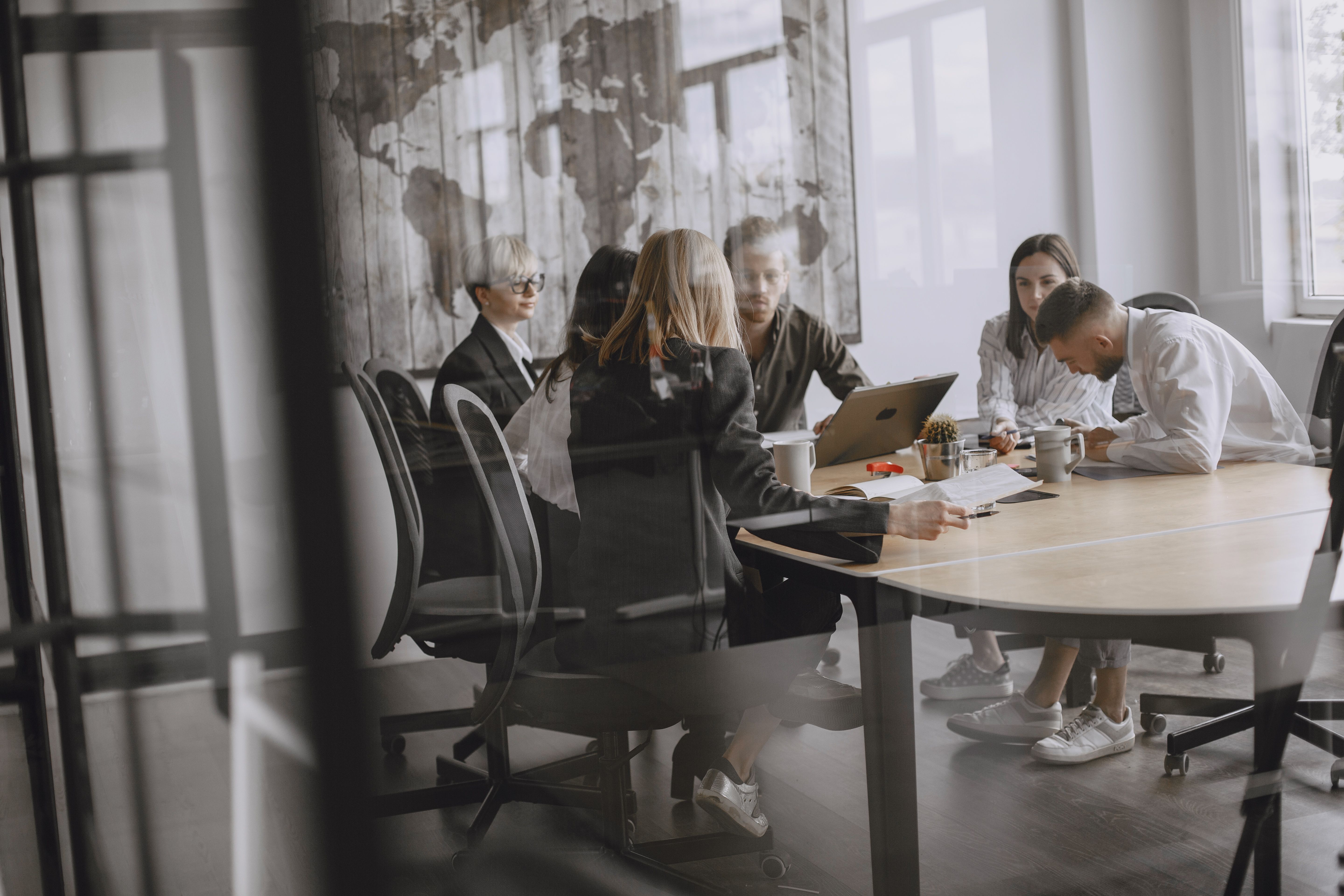 Equipe reunida em sala de reunião conduzindo a conversa em inglês para executivos