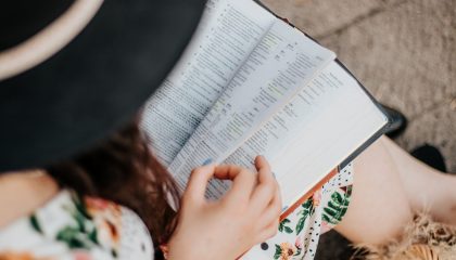 Estudante se preparando para o exame de proficiência em inglês TOEFL ou IELTS com anotações e livros sobre a mesa